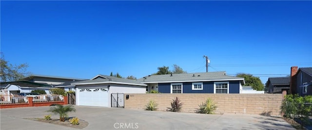 ranch-style house featuring a fenced front yard, driveway, and a garage