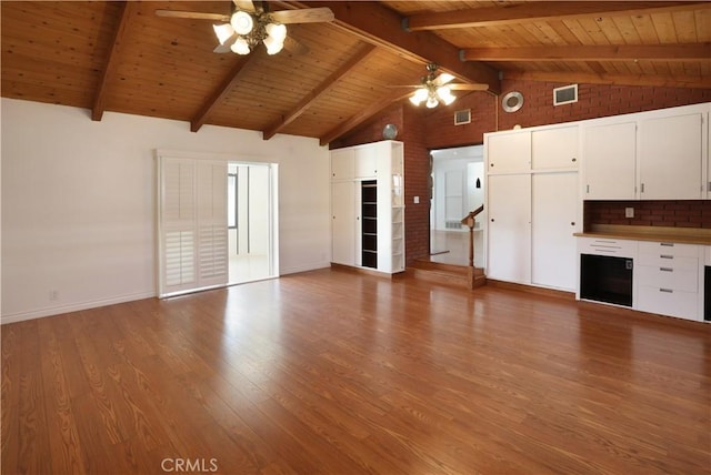 unfurnished living room with light wood-type flooring, vaulted ceiling with beams, visible vents, and a ceiling fan