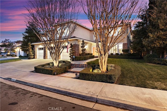 view of front of house with driveway, a lawn, and stucco siding