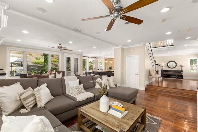 living area featuring dark wood-style floors, crown molding, recessed lighting, visible vents, and stairway