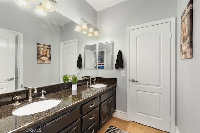 bathroom featuring double vanity, baseboards, and a sink