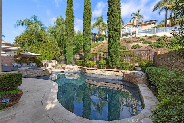 view of pool with a patio area, a fenced backyard, and a pool with connected hot tub