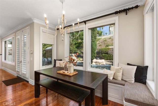 dining area with ornamental molding, breakfast area, plenty of natural light, and wood finished floors