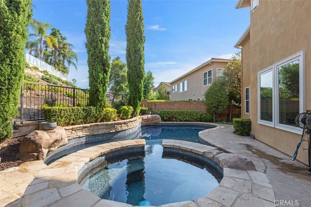 view of swimming pool with a fenced backyard and an in ground hot tub