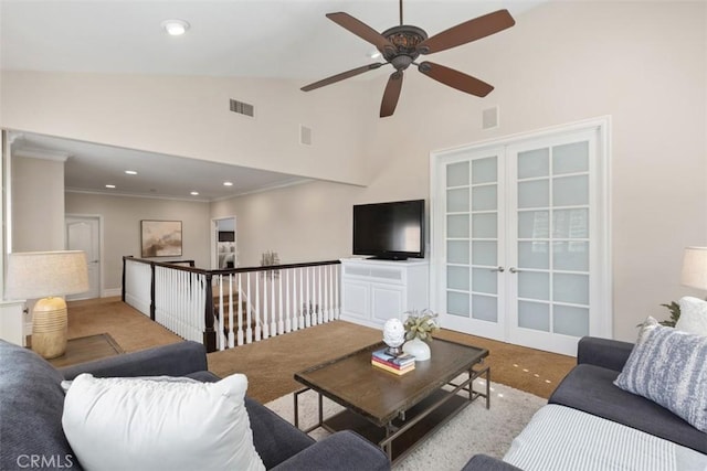 living room featuring light carpet, high vaulted ceiling, visible vents, and crown molding