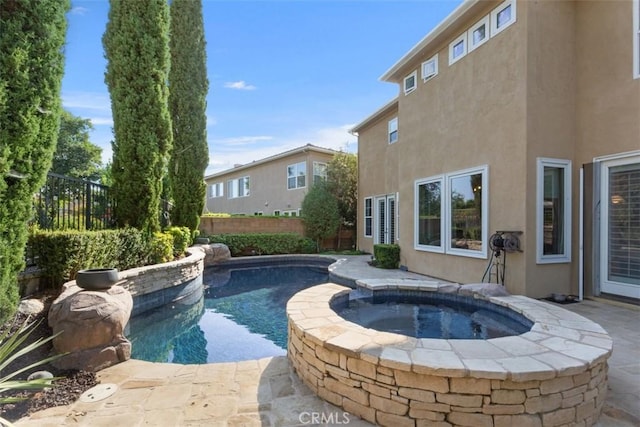 view of pool featuring a pool with connected hot tub and fence