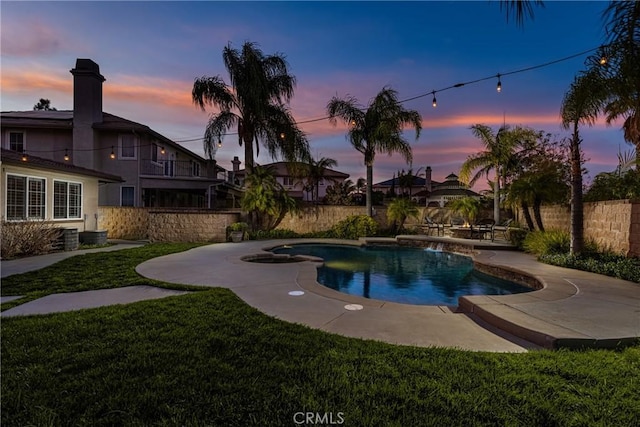 pool at dusk featuring a yard, fence, and a fenced in pool