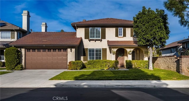 mediterranean / spanish-style home featuring a tile roof, stucco siding, an attached garage, a front yard, and driveway