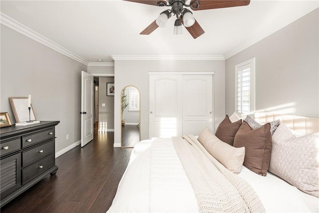 bedroom featuring baseboards, ceiling fan, ornamental molding, dark wood-type flooring, and a closet