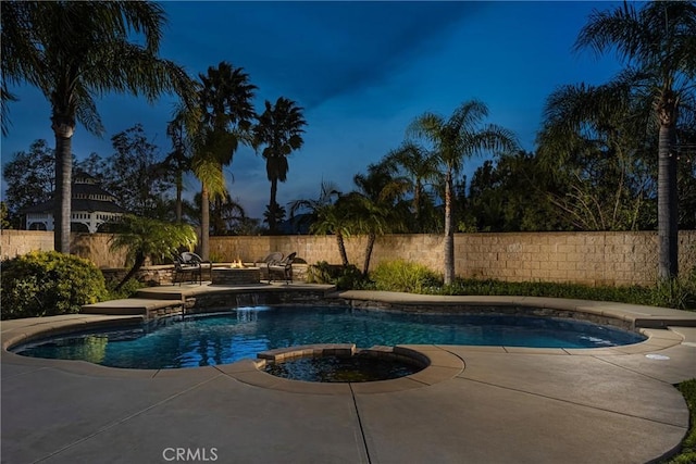 view of pool with a pool with connected hot tub, a fenced backyard, and a patio