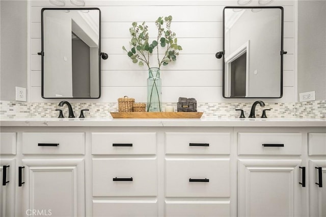 bathroom with double vanity, a sink, and decorative backsplash