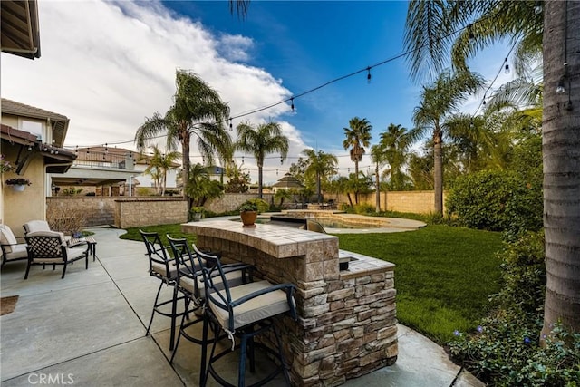 view of patio featuring fence and outdoor dry bar