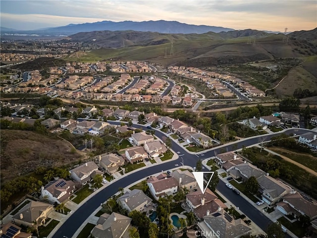 aerial view at dusk featuring a residential view and a mountain view