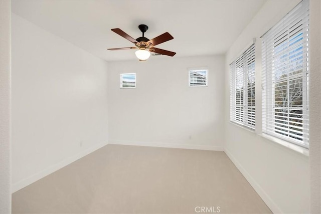 empty room featuring carpet, baseboards, and a ceiling fan