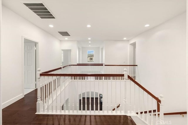 hall featuring visible vents, wood finished floors, an upstairs landing, and recessed lighting