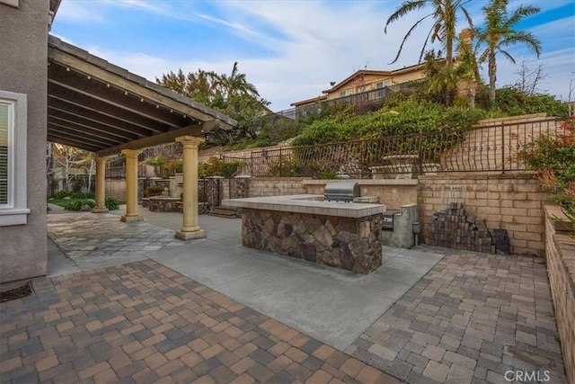 view of patio with exterior kitchen, a grill, and fence