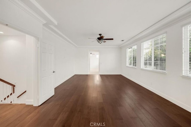 unfurnished room with dark wood-style floors, a ceiling fan, baseboards, and crown molding