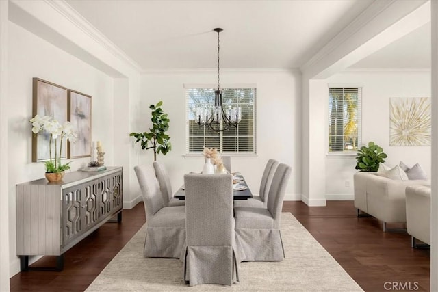 dining space featuring a chandelier, dark wood-style flooring, crown molding, and baseboards