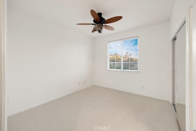 unfurnished bedroom with ceiling fan, a closet, and light colored carpet