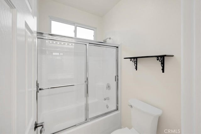 full bath featuring toilet and bath / shower combo with glass door