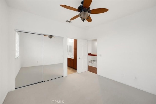 unfurnished bedroom with ceiling fan, visible vents, a closet, and ensuite bathroom