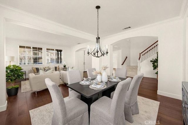 dining space with baseboards, visible vents, arched walkways, dark wood-style floors, and stairway