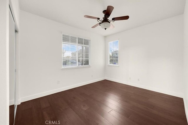 unfurnished bedroom with a ceiling fan, dark wood finished floors, and baseboards