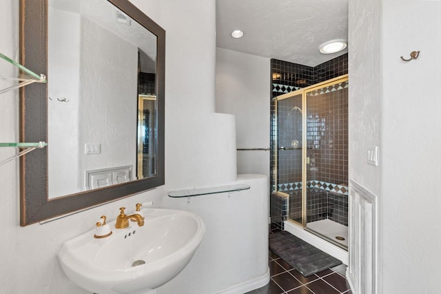 full bath featuring a stall shower, tile patterned flooring, a sink, and visible vents