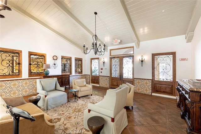 sitting room with french doors, wainscoting, a chandelier, wooden ceiling, and beamed ceiling