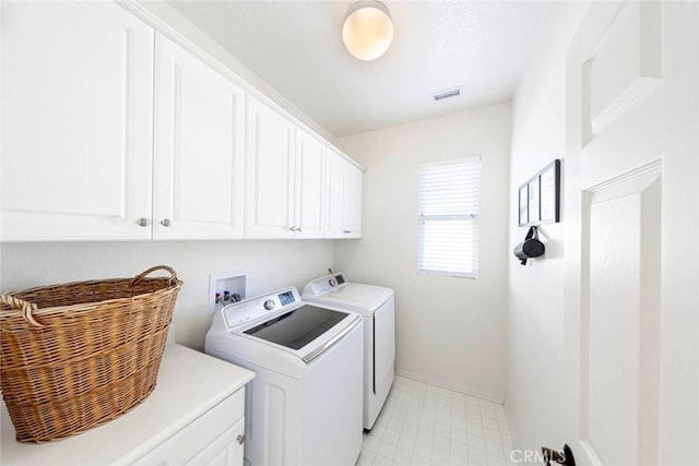 washroom with cabinet space, visible vents, and separate washer and dryer