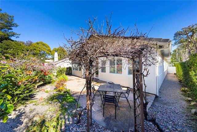 rear view of property with a patio, fence, and stucco siding