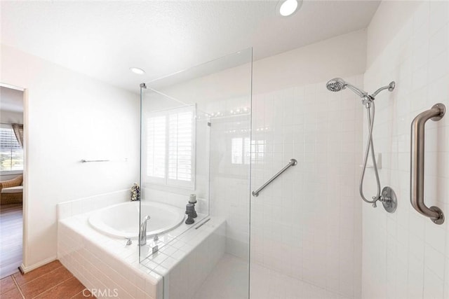 bathroom featuring recessed lighting, tile patterned flooring, a bath, and tiled shower