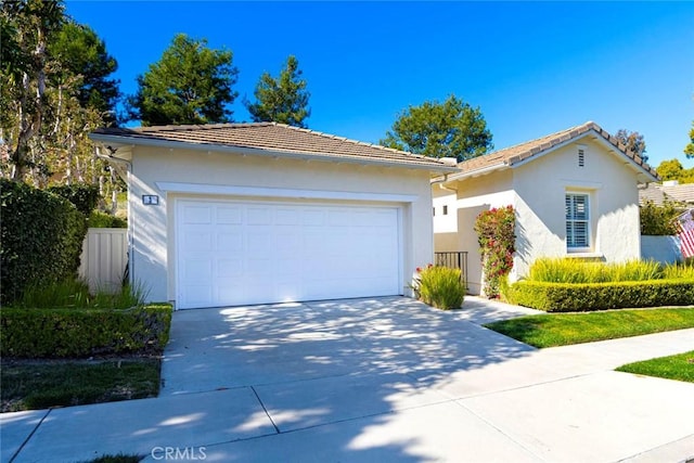 ranch-style house featuring a garage, concrete driveway, a tile roof, and stucco siding