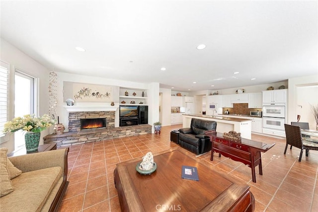 living area with built in shelves, light tile patterned flooring, a fireplace, and recessed lighting