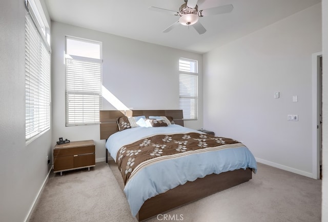 bedroom featuring baseboards, ceiling fan, and light colored carpet