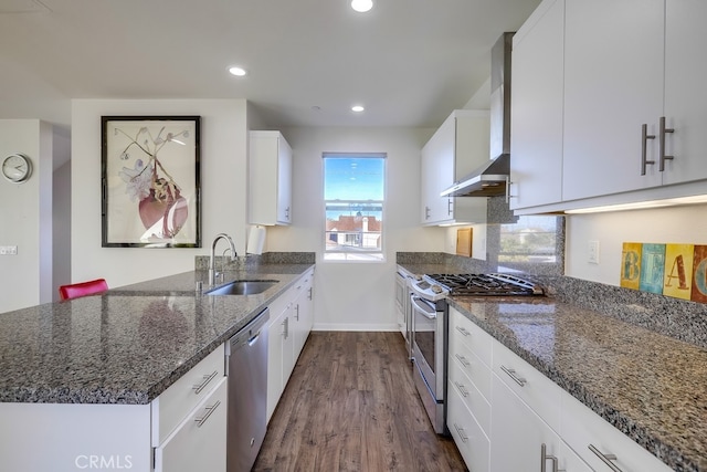 kitchen with white cabinets, dark stone countertops, stainless steel appliances, and a sink