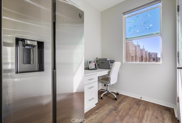 home office featuring baseboards, wood finished floors, and a city view