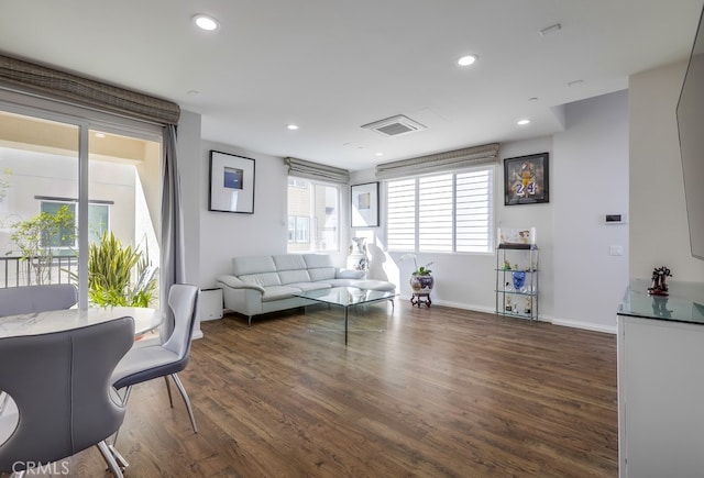 living area with dark wood-style floors, recessed lighting, visible vents, and baseboards