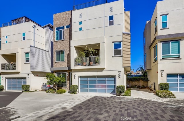 view of front of property featuring driveway, an attached garage, and stucco siding