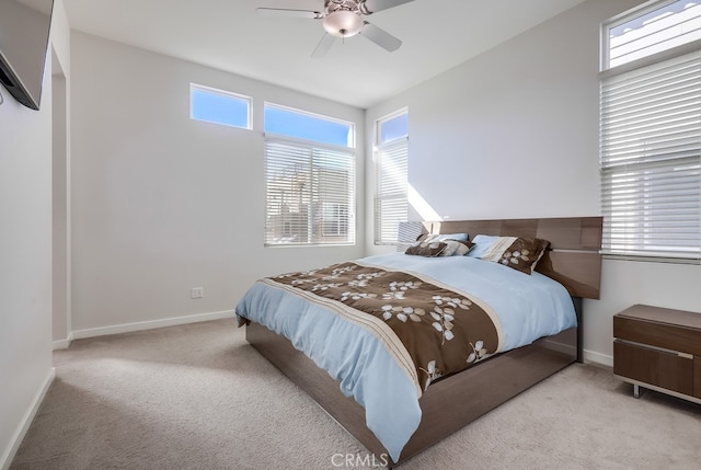 bedroom with baseboards, a ceiling fan, and light colored carpet