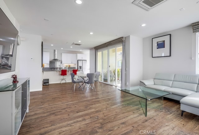 living room featuring dark wood-type flooring, recessed lighting, and visible vents