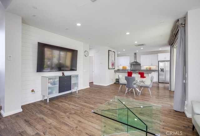 living room with baseboards, wood finished floors, visible vents, and recessed lighting