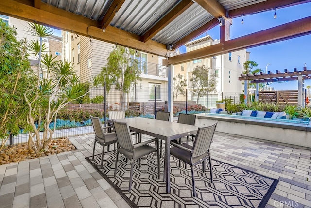 view of patio / terrace with a water view, fence, a pergola, and outdoor dining space