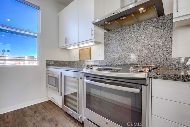 kitchen with white cabinets, wall chimney exhaust hood, wine cooler, and stainless steel appliances