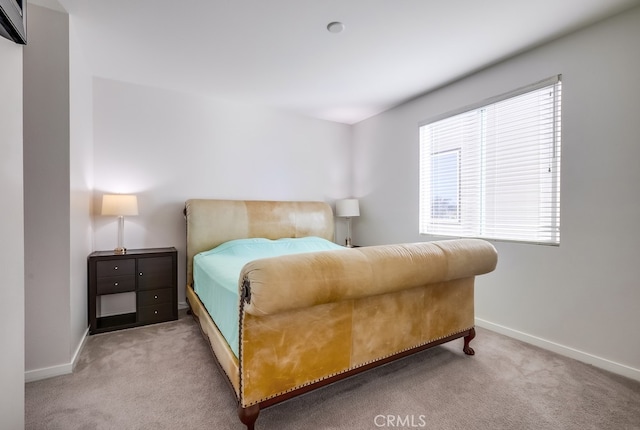 bedroom with light carpet and baseboards