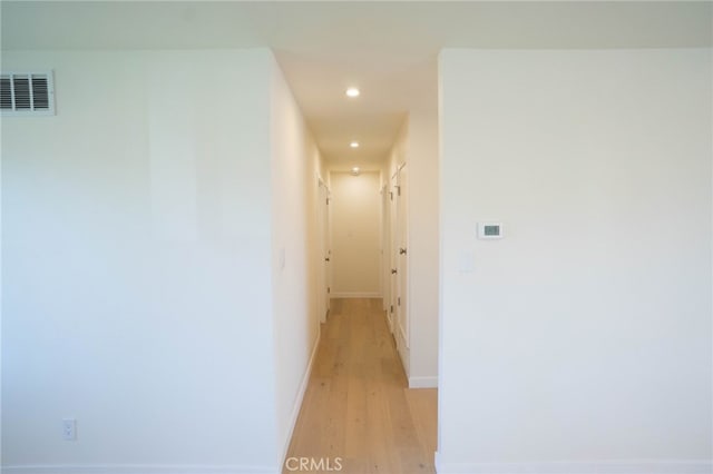 hall featuring baseboards, light wood finished floors, visible vents, and recessed lighting