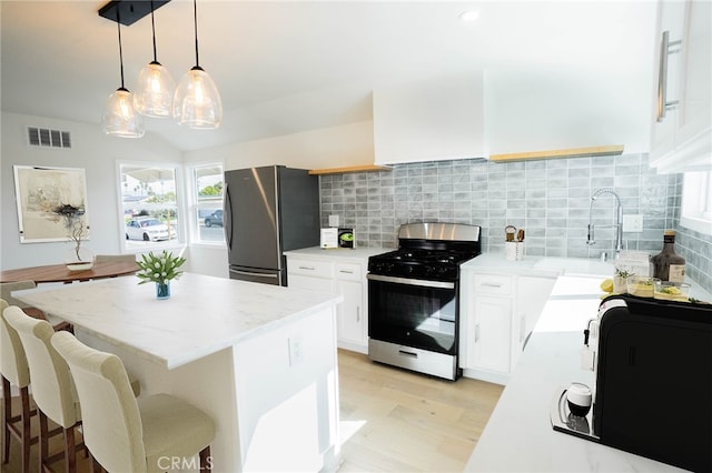 kitchen featuring stainless steel appliances, white cabinets, light countertops, and custom range hood