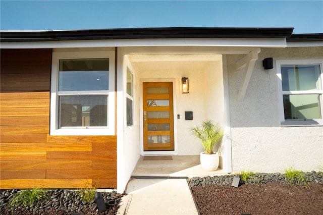 property entrance with stucco siding