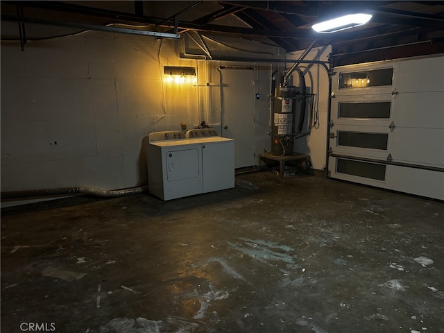 basement featuring a garage, secured water heater, and separate washer and dryer