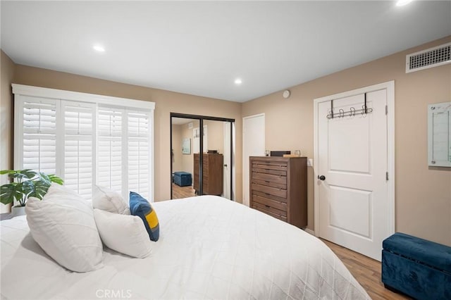 bedroom with light wood-type flooring, visible vents, two closets, and recessed lighting